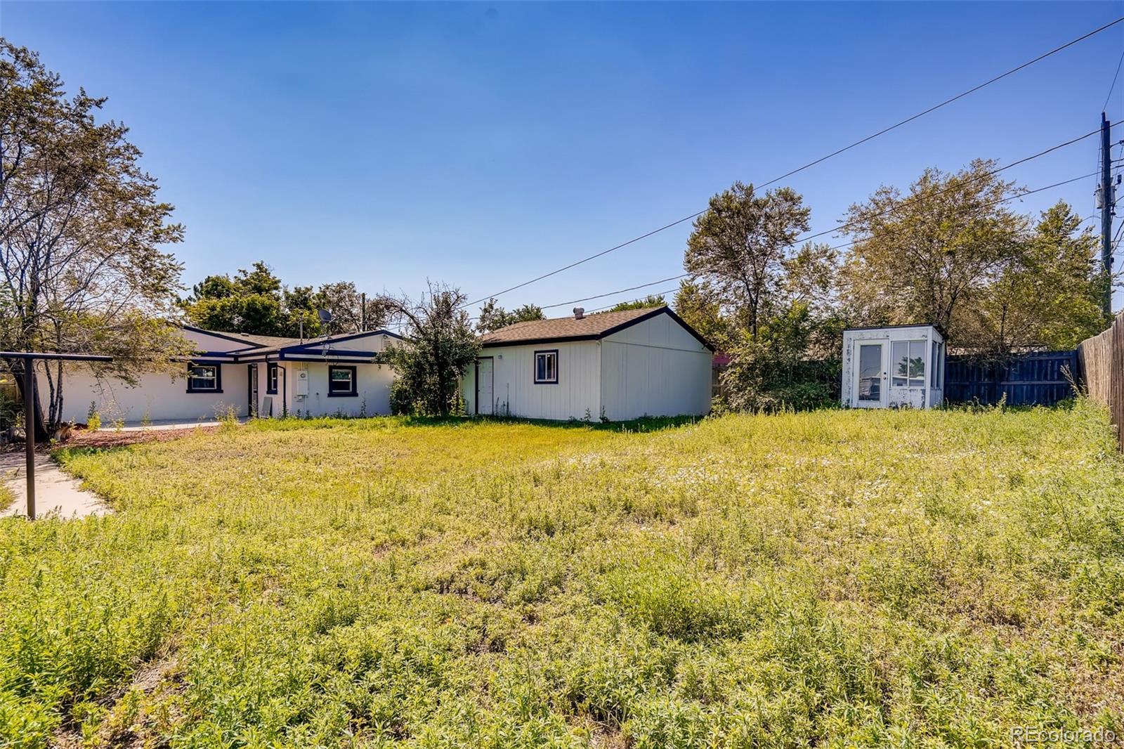 5535 Tejon Street Denver, CO 80221 - Photo 22 of 23 a front view of house with yard and trees in the background
