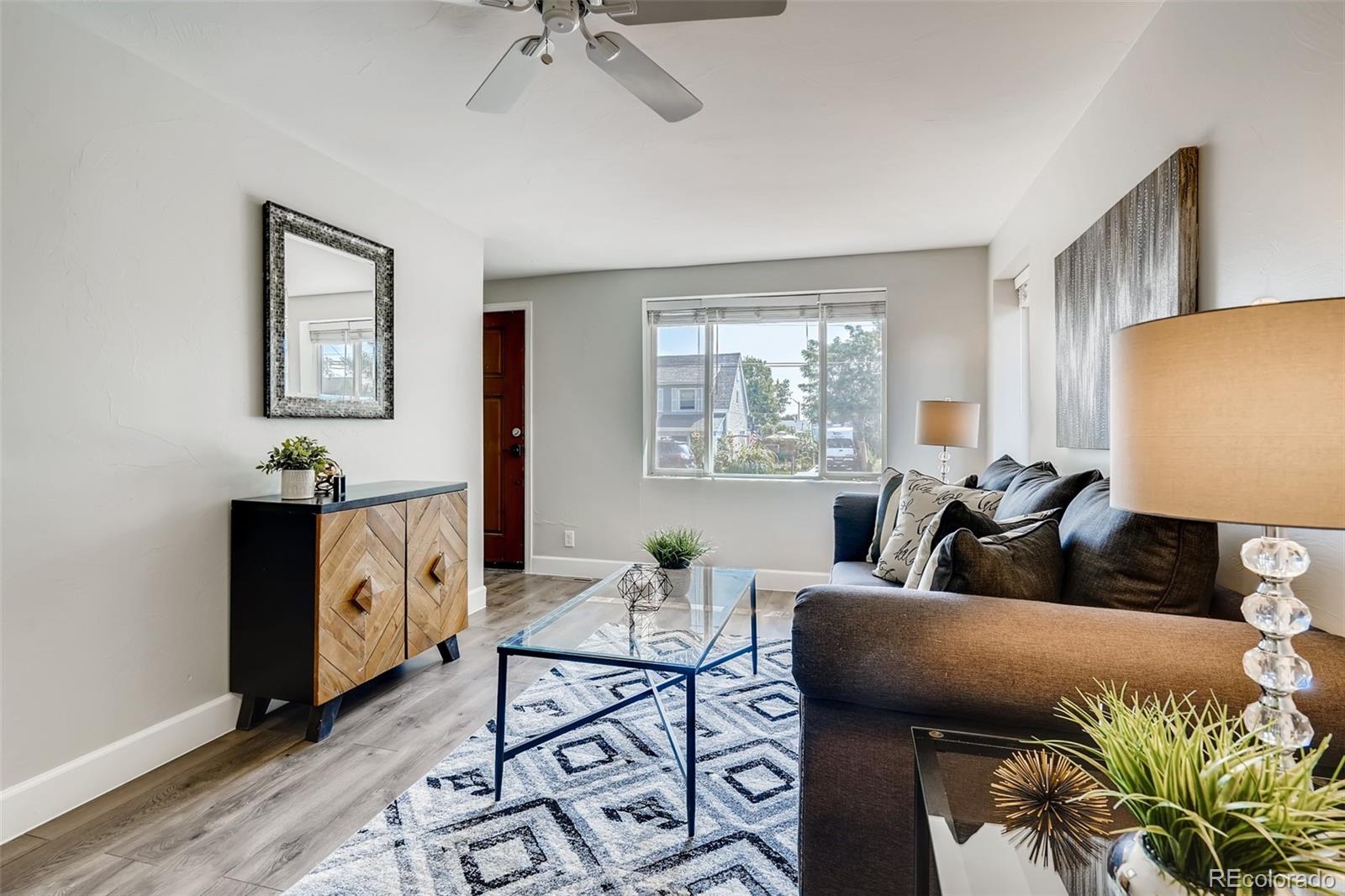 5535 Tejon Street Denver, CO 80221 - Photo 6 of 23 a living room with furniture a chandelier and a window