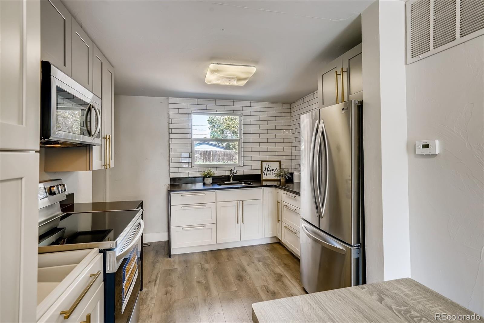 5535 Tejon Street Denver, CO 80221 - Photo 8 of 23 a kitchen with a sink a refrigerator and cabinets