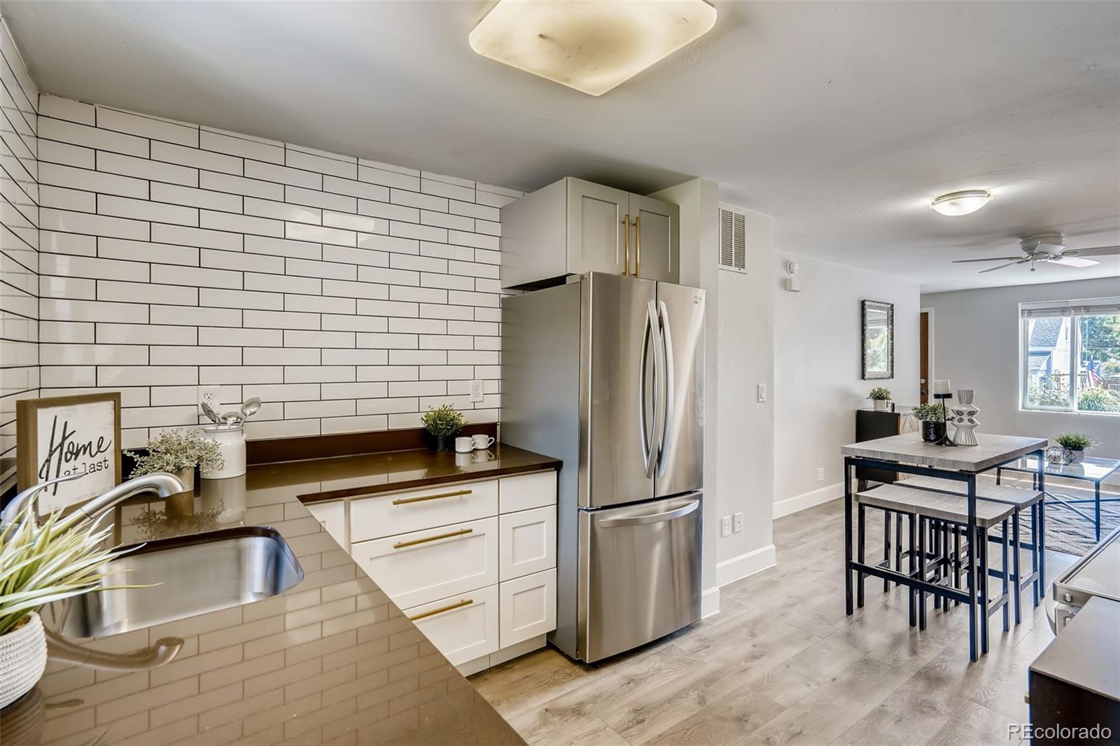 5535 Tejon Street Denver, CO 80221 - Photo 10 of 23 a kitchen with stainless steel appliances a refrigerator a sink a stove a table and chairs