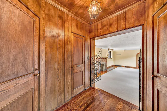 a view of a hallway with wooden floor and windows