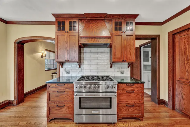 a view of an empty room with wooden floor and window