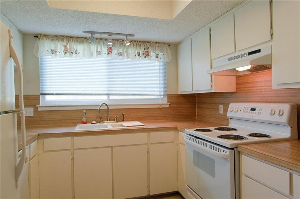 12902 Old San Antonio Road, Unit A Manchaca, TX 78652 - Photo 2 of 9 Kitchen featuring white cabinetry, wood-finish countertops, and a white electric range with overhead ventilation