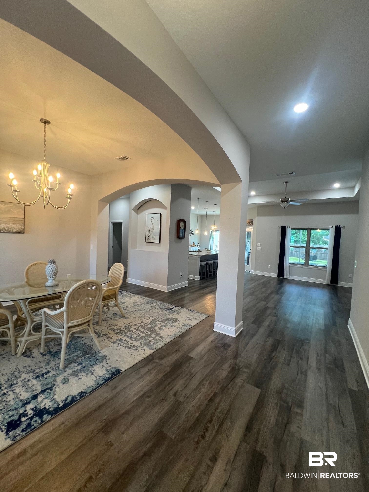 32915 Arbor Ridge Circle Lillian, AL 36549 - Photo 4 of 26 Dining room featuring dark wood-style floors, arched walkways, ceiling fan, a chandelier, and recessed lighting