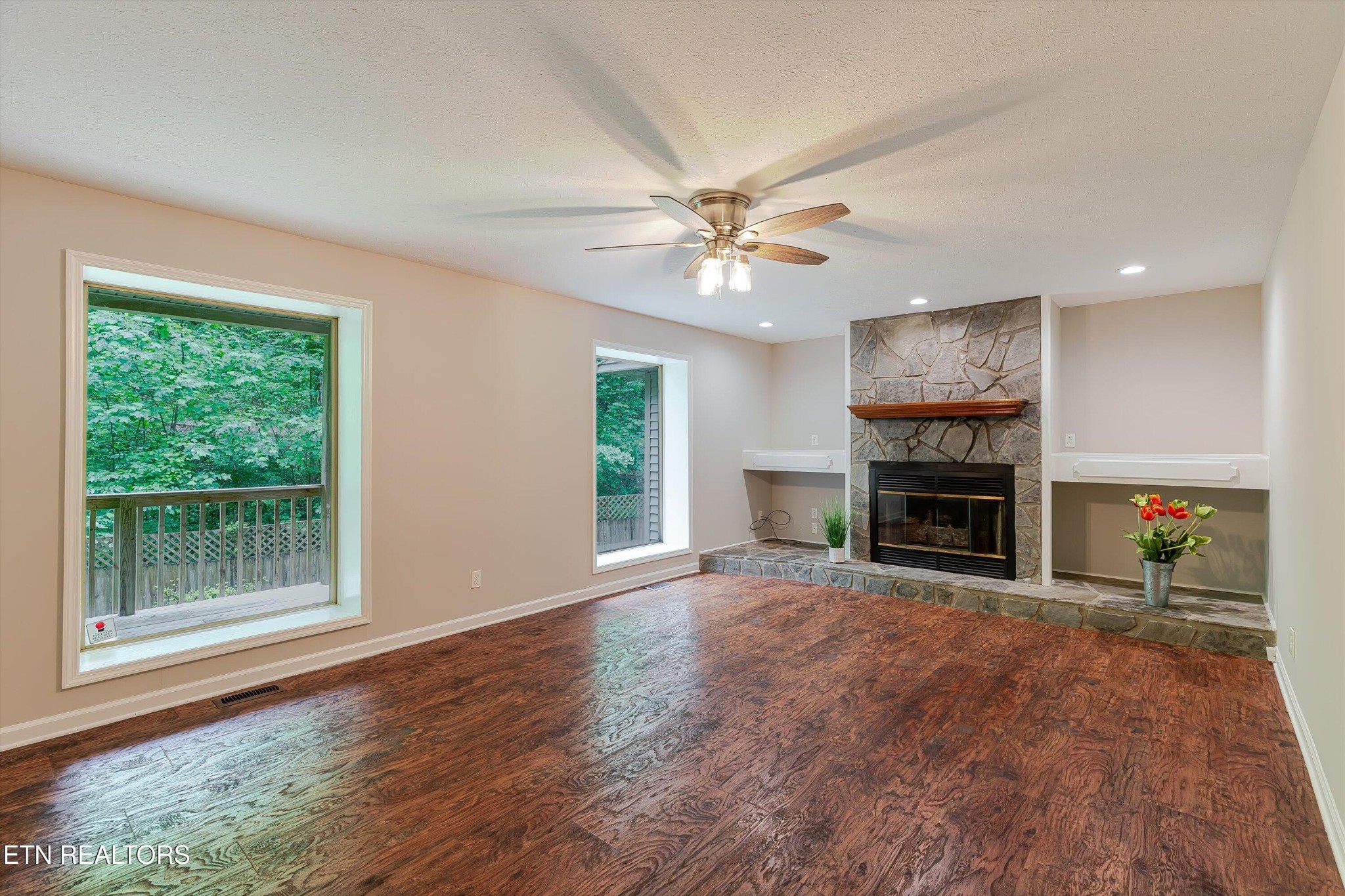 147 California Avenue Oak Ridge, TN 37830 - Photo 11 of 39 an empty room with windows fireplace and a ceiling fan