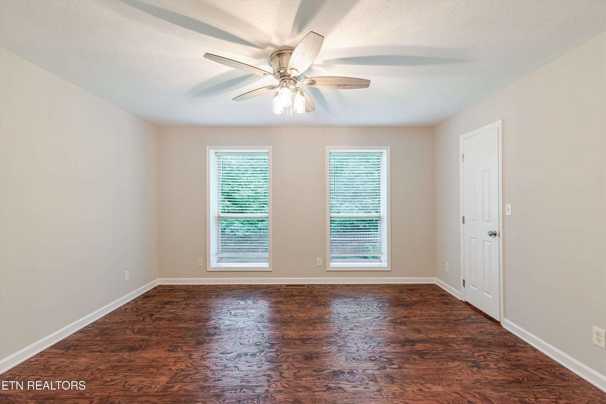 147 California Avenue Oak Ridge, TN 37830 - Photo 23 of 39 an empty room with wooden floor chandelier fan and windows