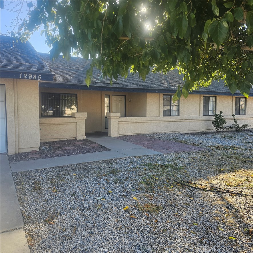 12985 Pacoima Road Victorville, CA 92392 - Photo 1 of 1 a front view of a house with a yard and a garage