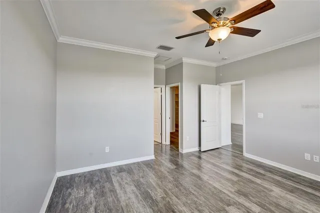 an empty room with a window and a ceiling fan