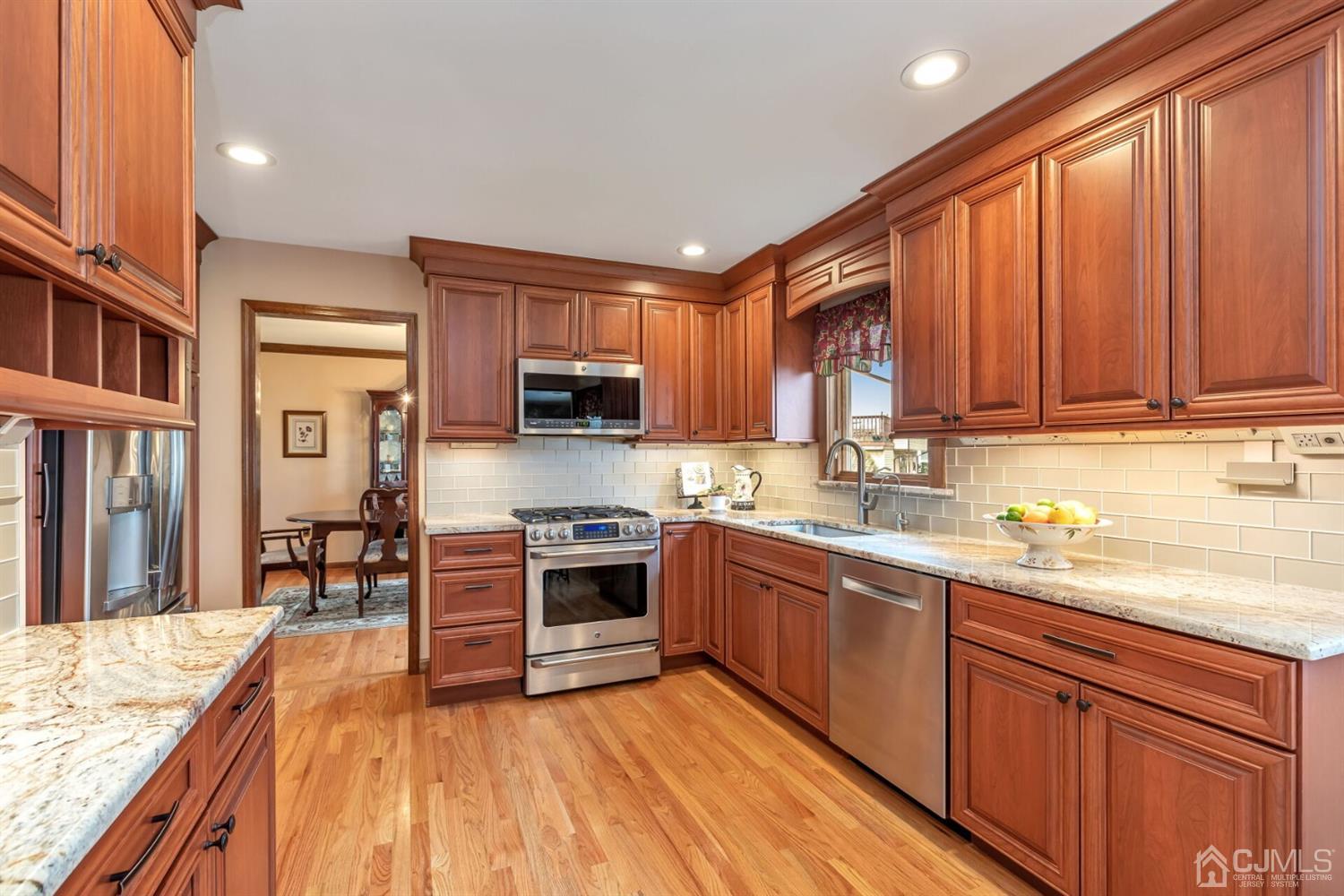 28 Harkins Road Milltown, NJ 08850 - Photo 15 of 46 a kitchen with stainless steel appliances granite countertop wooden cabinets a sink dishwasher a stove and a refrigerator with wooden floor