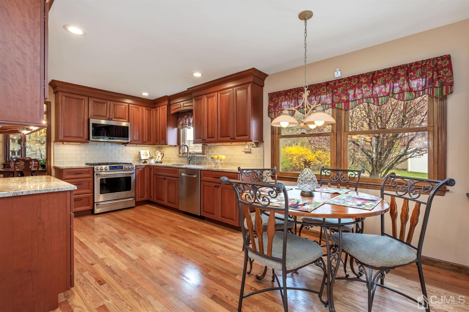 28 Harkins Road Milltown, NJ 08850 - Photo 18 of 46 a kitchen with stainless steel appliances granite countertop wooden cabinets a stove top oven a granite counter space and a center island
