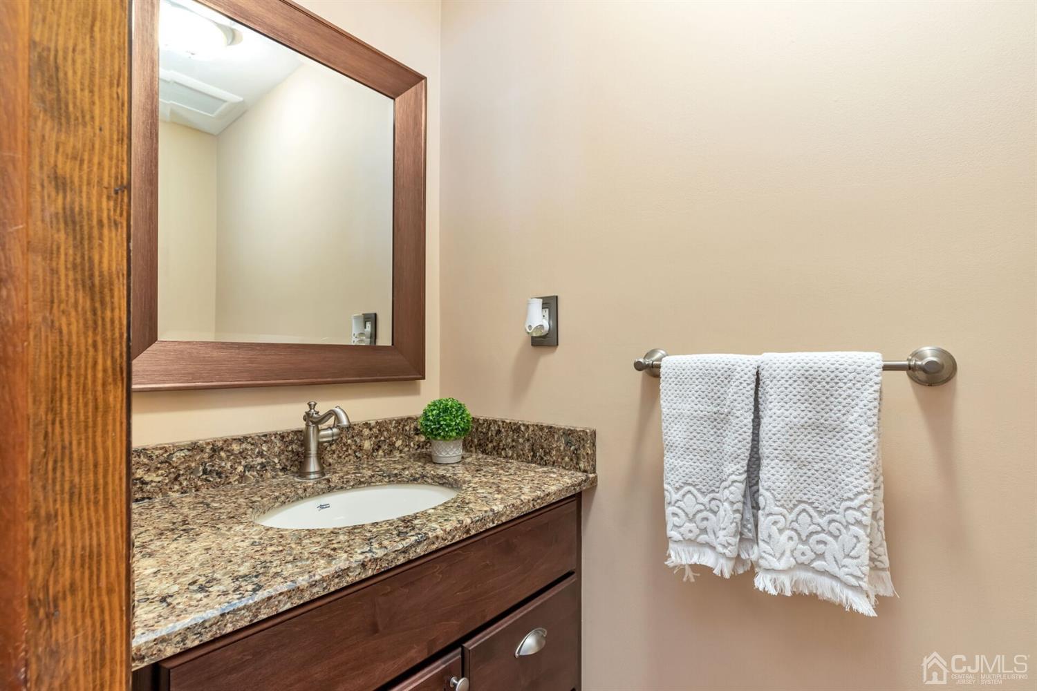 28 Harkins Road Milltown, NJ 08850 - Photo 23 of 46 a bathroom with a granite countertop sink and a mirror