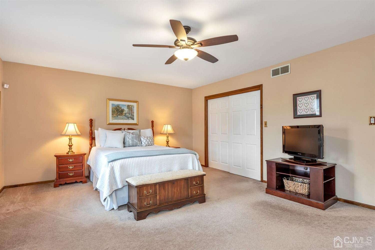 28 Harkins Road Milltown, NJ 08850 - Photo 26 of 46 a bedroom with a bed flat screen tv and a ceiling fan