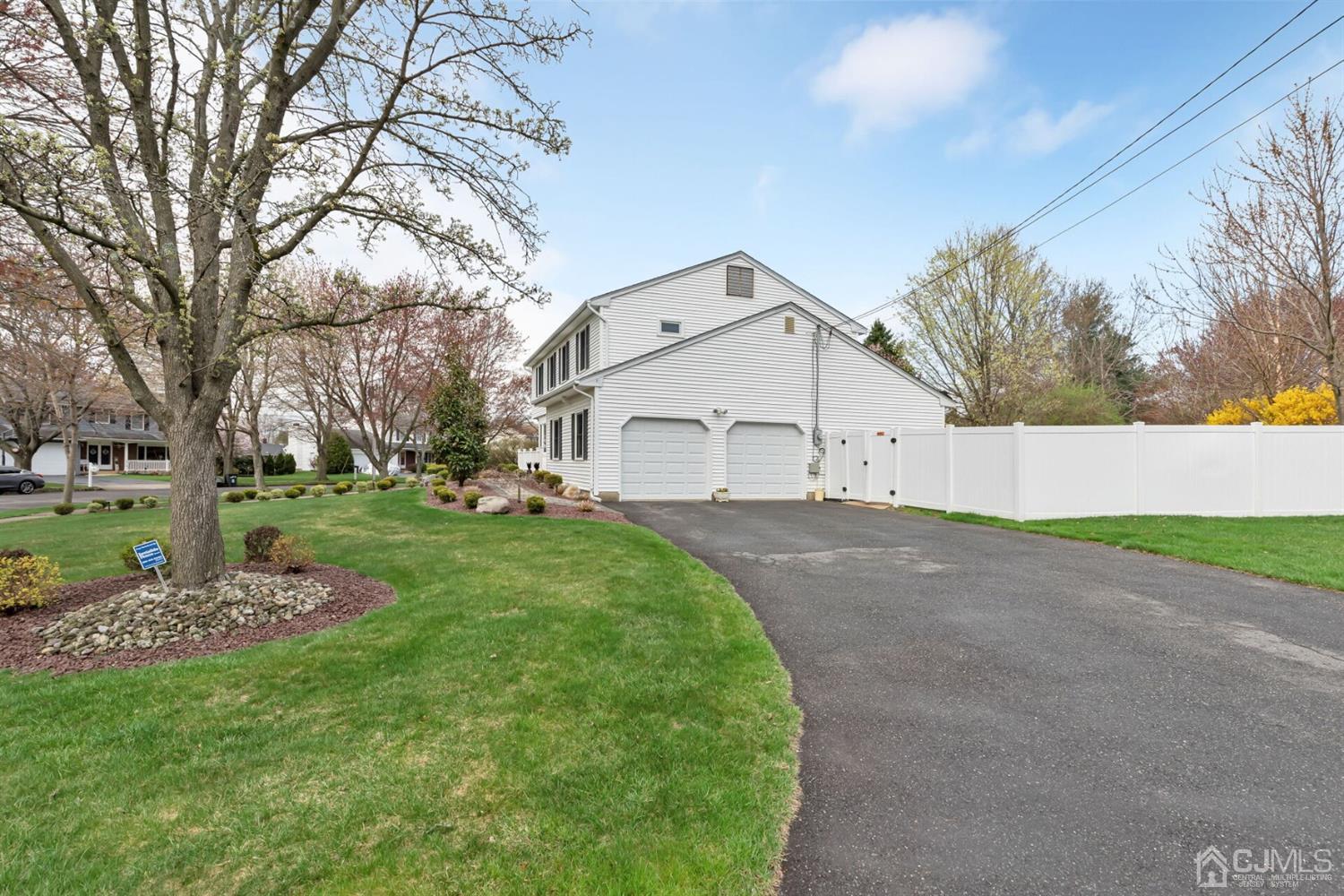 28 Harkins Road Milltown, NJ 08850 - Photo 44 of 46 a view of a white house with a big yard and large trees