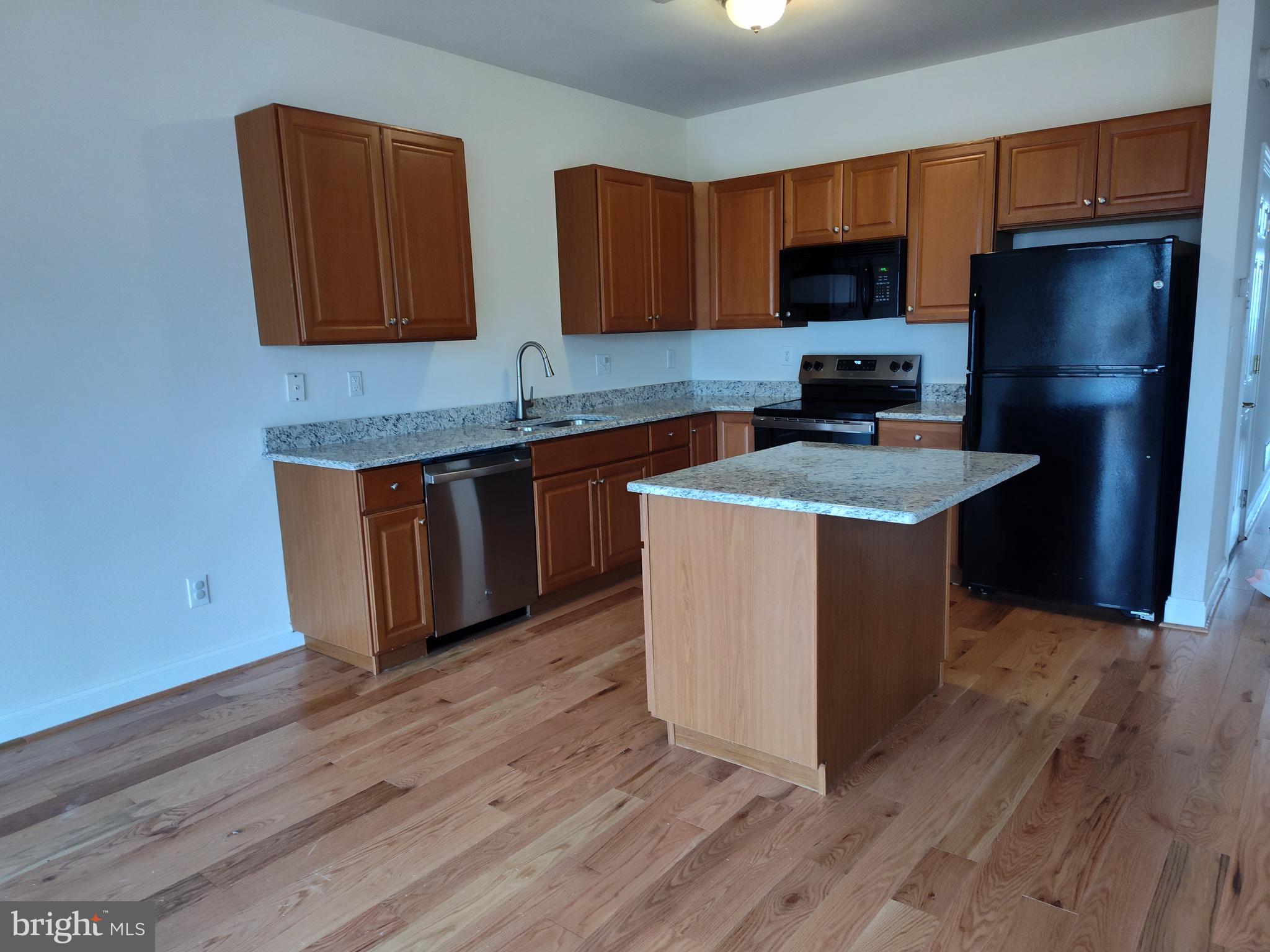 63 Sugar Maple Road Barto, PA 19504 - Photo 3 of 3 a kitchen with stainless steel appliances granite countertop a stove a sink dishwasher a refrigerator and a microwave oven with wooden floor