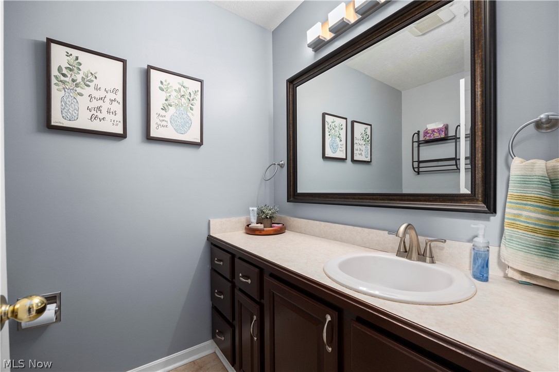 3270 North Ridge Road Vermilion, OH 44089 - Photo 25 of 49 First floor powder room with an integrated sink, brushed nickel faucet, and a large framed mirror