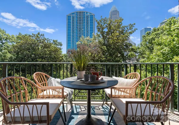 a balcony with a potted plant and outdoor seating