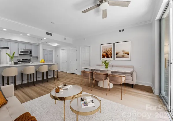 a living room with furniture and a dining table with kitchen view