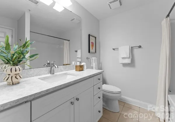 a bathroom with a granite countertop sink a toilet and a mirror
