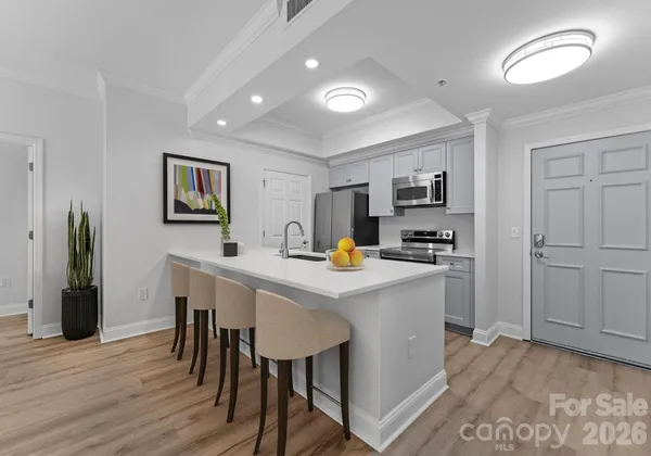 a kitchen with stainless steel appliances a dining table chairs and wooden floor