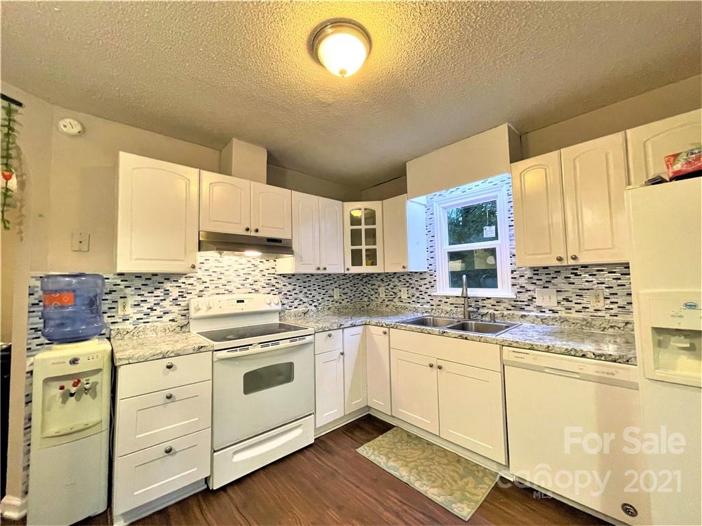 7002 Ware Road Charlotte, NC 28212 - Photo 7 of 21 a kitchen with stainless steel appliances granite countertop a sink and cabinets with wooden floor