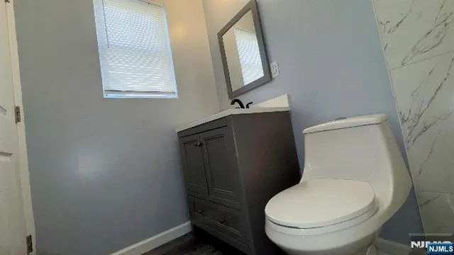 a white toilet sitting next to a bathroom sink and vanity