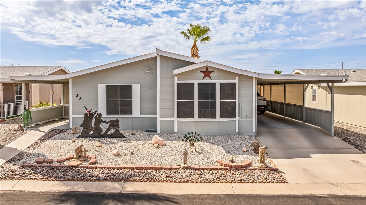 View of front of home with an attached carport, concrete driveway, and a sunroom