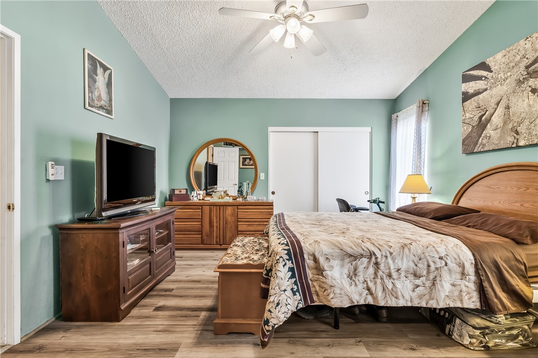 1545 East El Rodeo Road, Unit 58 Fort Mohave, AZ 86426 - Photo 20 of 47 Bedroom with light wood-type flooring, a textured ceiling, and a ceiling fan