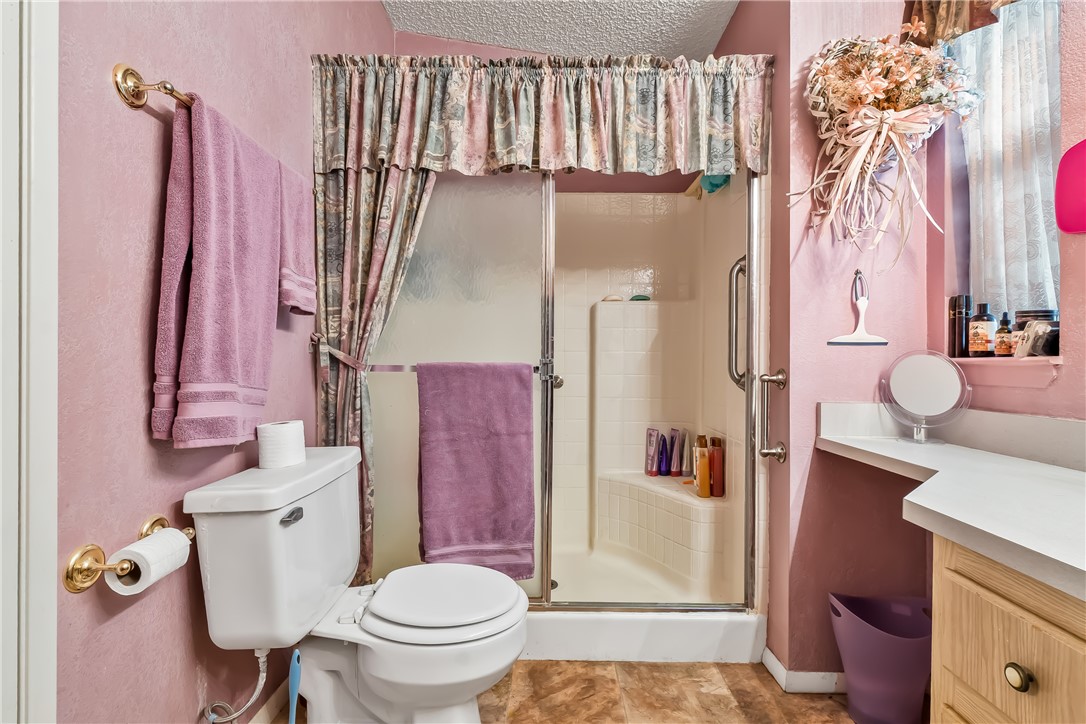 1545 East El Rodeo Road, Unit 58 Fort Mohave, AZ 86426 - Photo 23 of 47 Bathroom with vanity, a shower stall, and a textured ceiling
