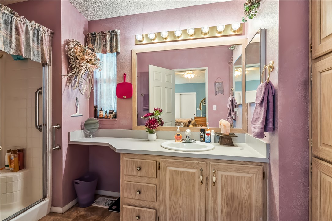 1545 East El Rodeo Road, Unit 58 Fort Mohave, AZ 86426 - Photo 25 of 47 Bathroom with a stall shower, vanity, and a textured ceiling