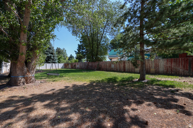 270 East 100 North Monroe, UT 84754 - Photo 44 of 65 Expansive backyard featuring a manicured lawn, mature trees, and a surrounding privacy fence