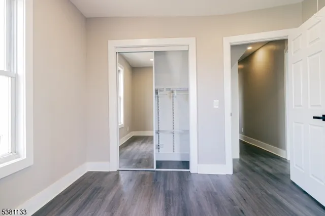 an empty room with wooden floor and a window