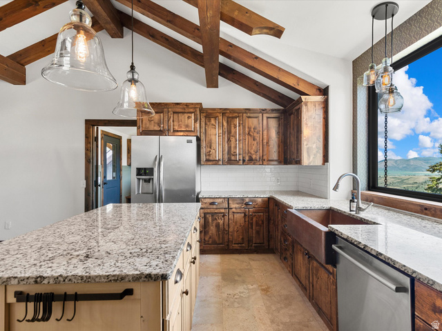 1225 Old Oregon Road Soda Springs, ID 83276 - Photo 14 of 67 Vaulted ceiling with exposed wood beams, stainless steel appliances, copper farmhouse sink, granite countertops, and panoramic outdoor scenery