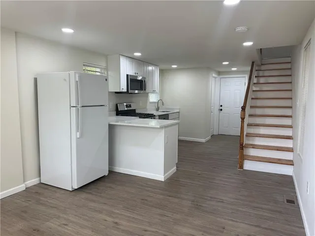a kitchen with stainless steel appliances a refrigerator sink and microwave
