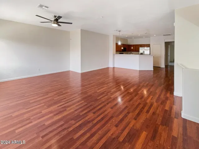 a view of a room with wooden floor and a ceiling fan