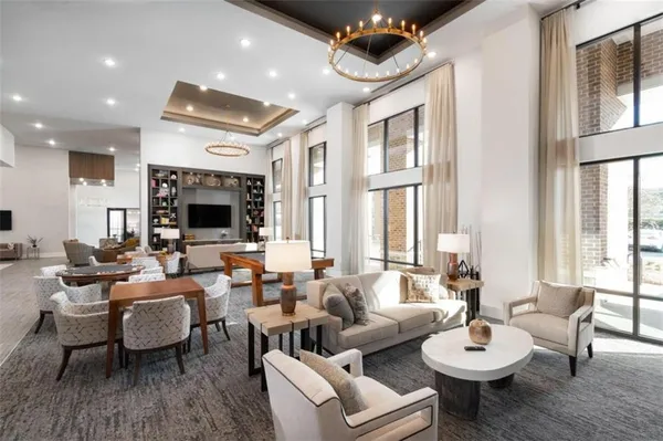 a living room with furniture kitchen view and a large window