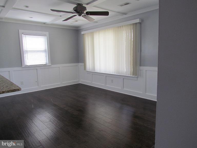 772 223rd Street Pasadena, MD 21122 - Photo 2 of 13 an empty room with wooden floor windows and fan