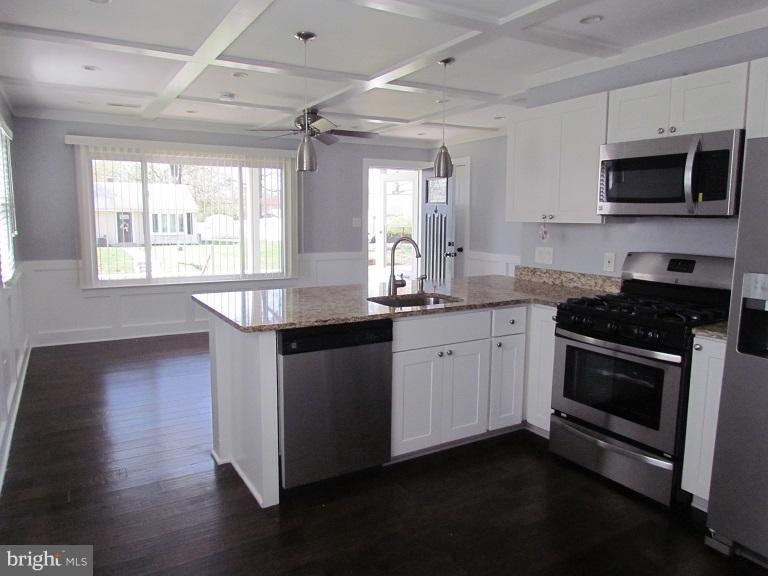 772 223rd Street Pasadena, MD 21122 - Photo 6 of 13 a kitchen with granite countertop stainless steel appliances a stove sink and microwave