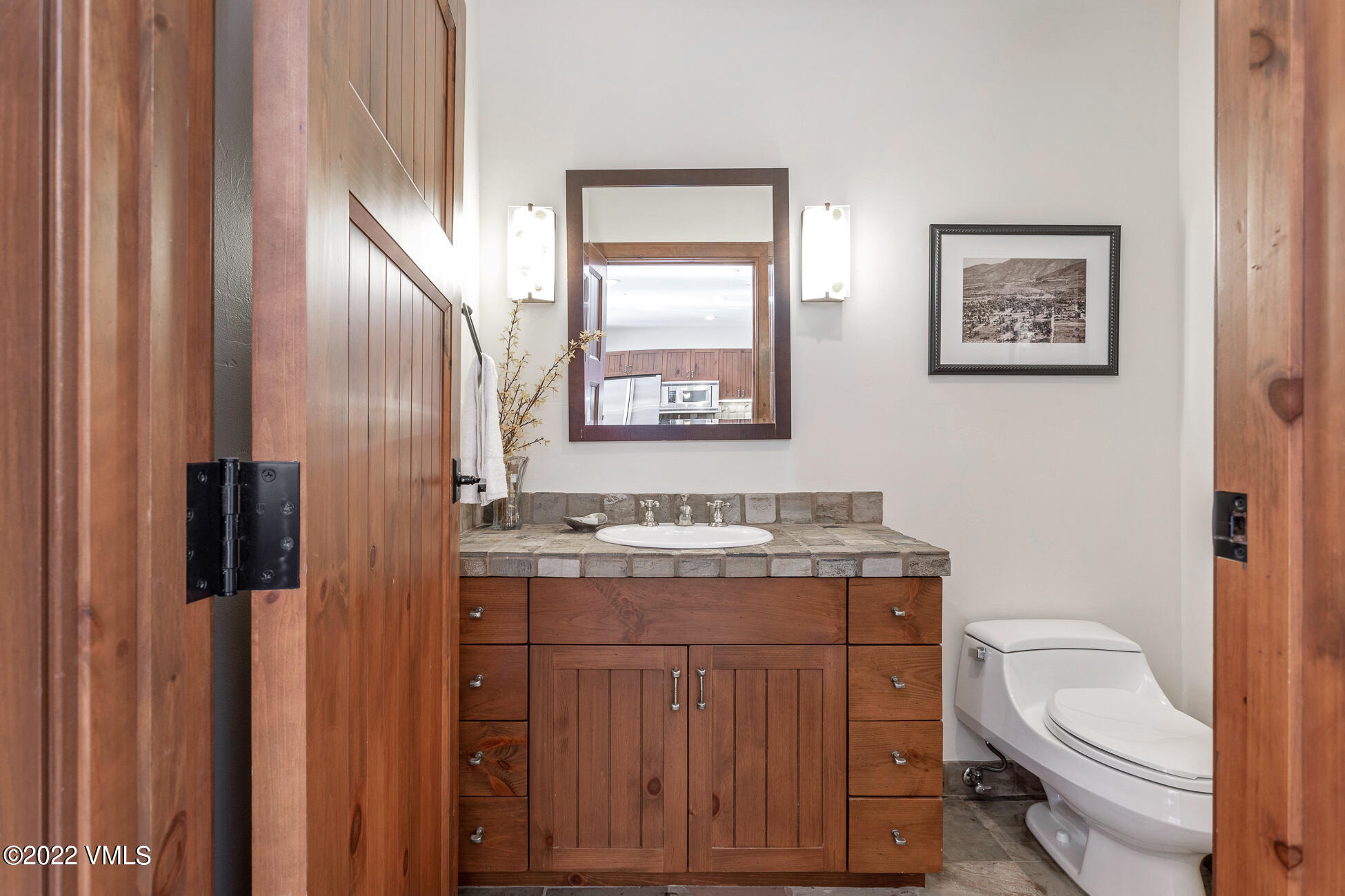 180 Daybreak Ridge Road, Unit 813 Avon, CO 81620 - Photo 16 of 46 a bathroom with a granite countertop toilet sink and mirror