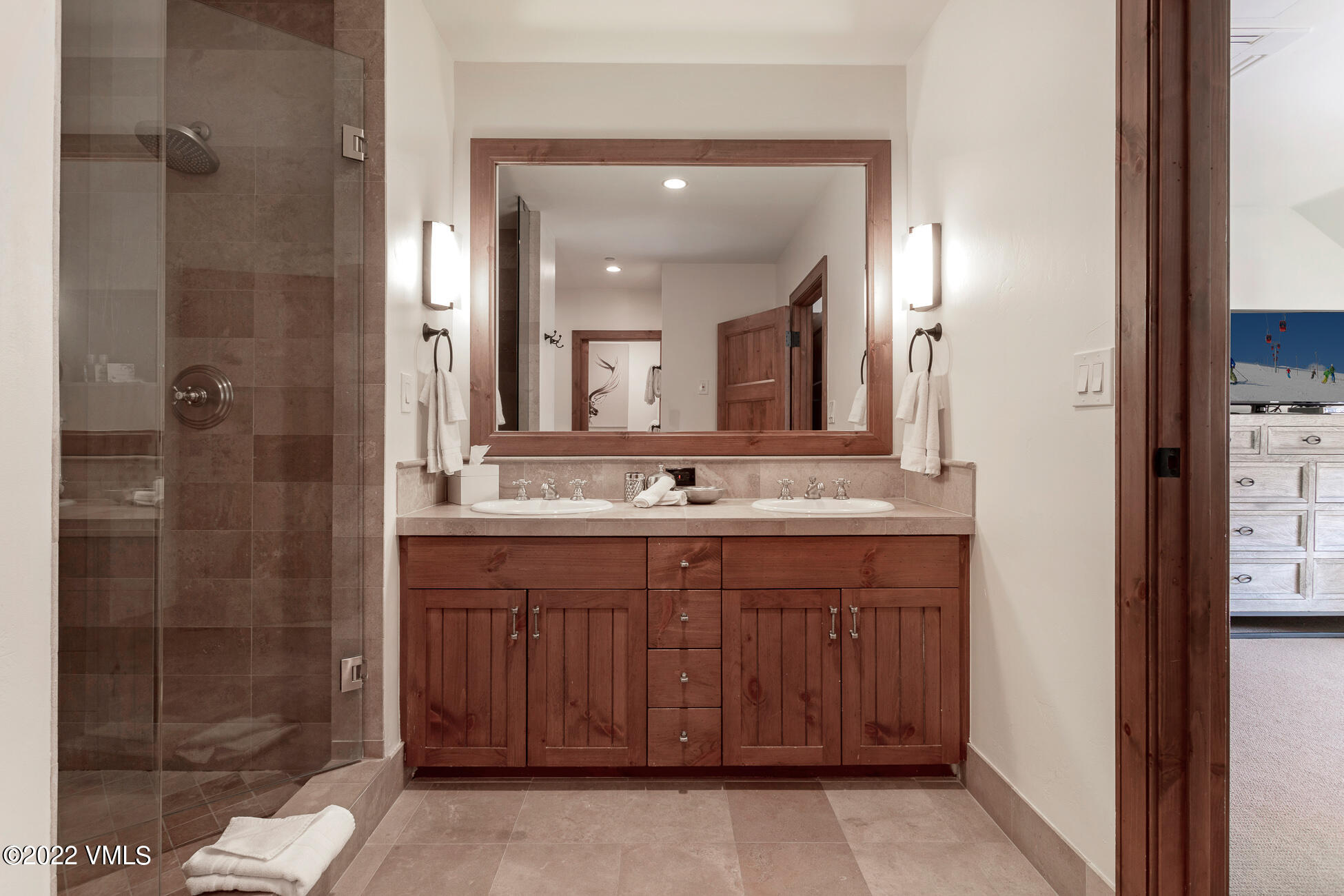 180 Daybreak Ridge Road, Unit 813 Avon, CO 81620 - Photo 19 of 46 a bathroom with a granite countertop sink a mirror and a shower