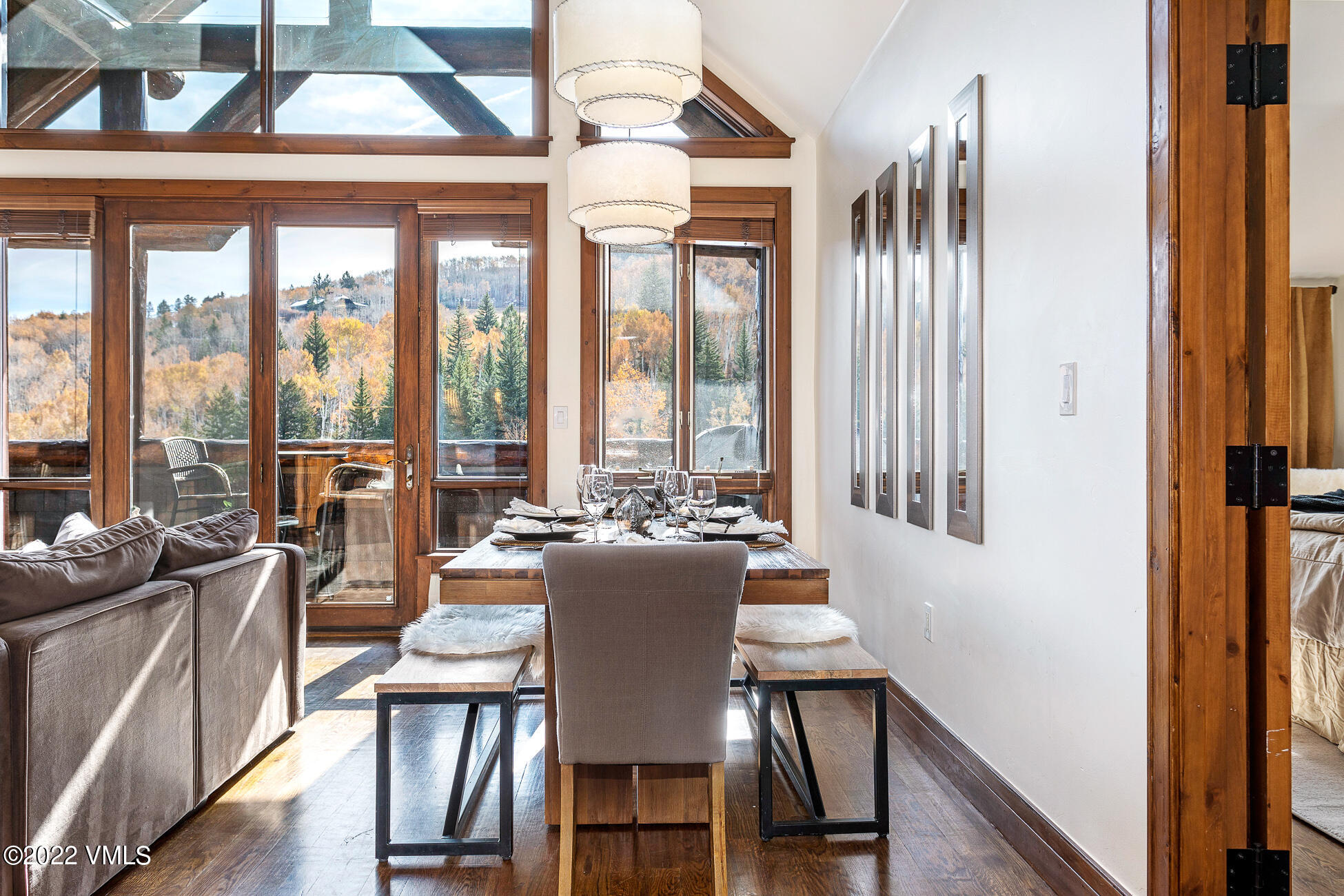 180 Daybreak Ridge Road, Unit 813 Avon, CO 81620 - Photo 3 of 46 a view of a dining room with furniture large windows and wooden floor