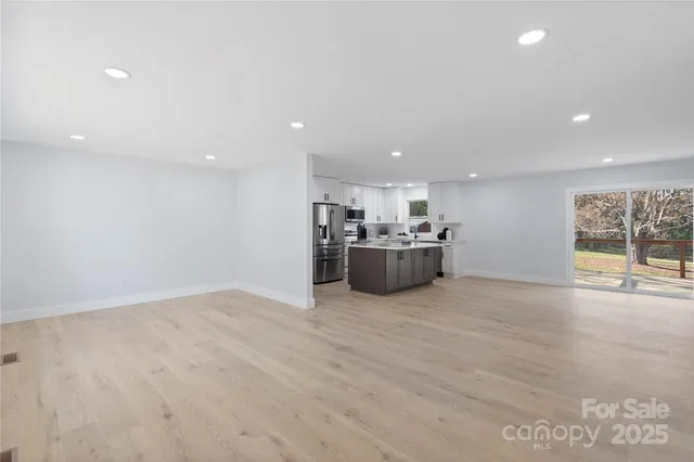 a view of a big room with wooden floor and windows