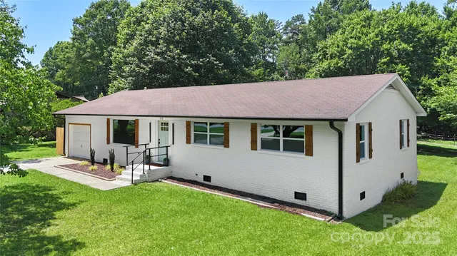 a view of house with backyard and a patio