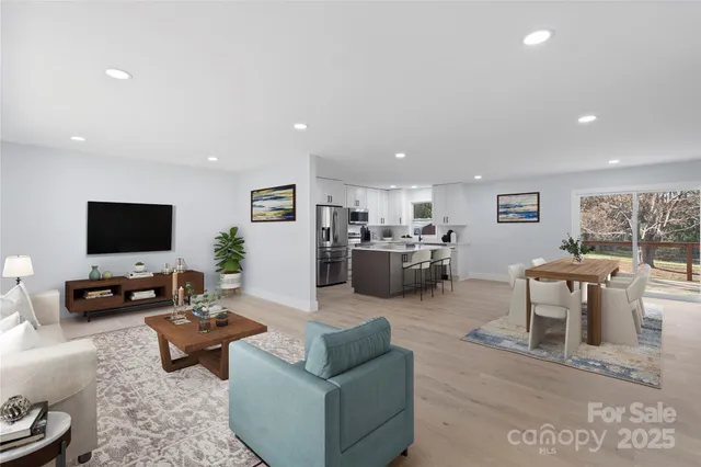 a living room with furniture flat screen tv and couches