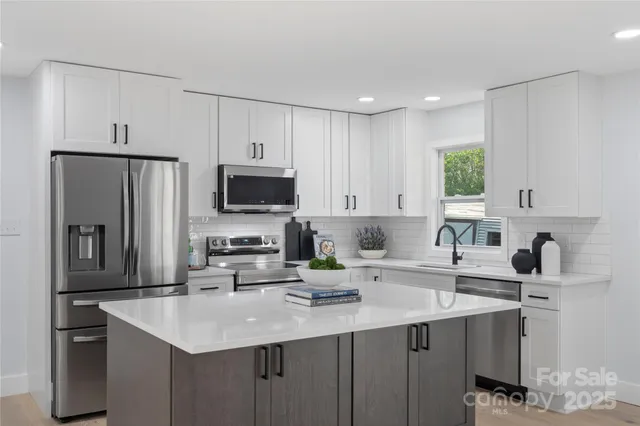a kitchen with a sink stainless steel appliances and white cabinets