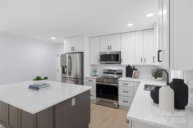 a kitchen with stainless steel appliances kitchen island granite countertop a sink dishwasher stove and refrigerator with wooden floor