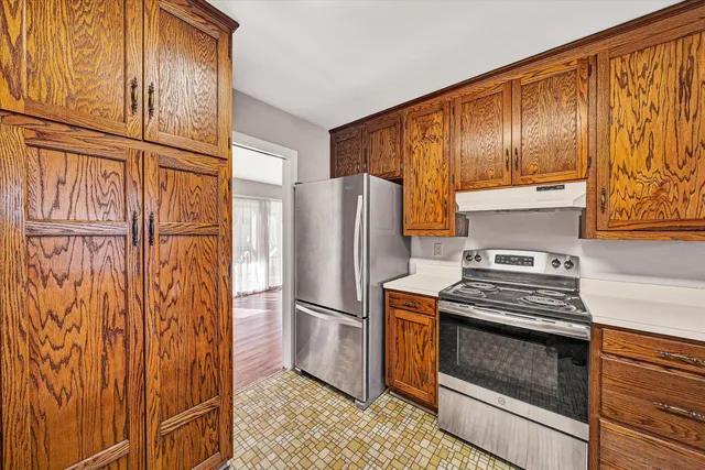 a kitchen with stainless steel appliances granite countertop a refrigerator and a stove top oven