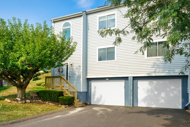 a view of a house with a yard and large tree