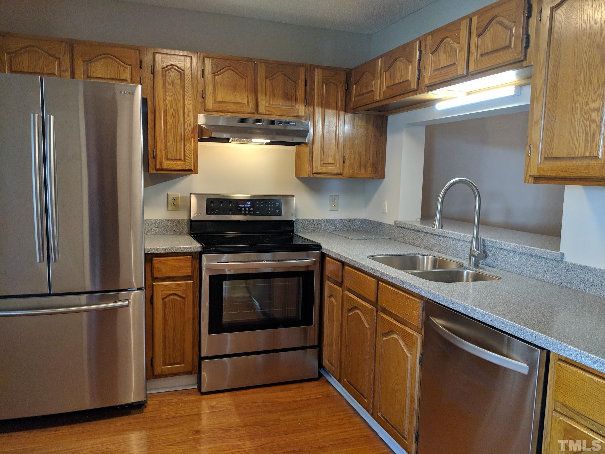 4626 Townesbury Lane Raleigh, NC 27612 - Photo 2 of 8 a kitchen with granite countertop a refrigerator stove and sink