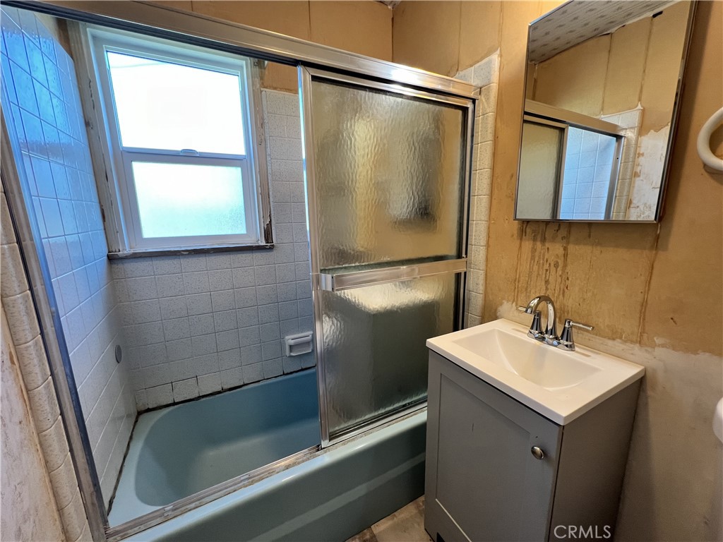 9467 Palm Lane Fontana, CA 92335 - Photo 3 of 13 a bathroom with a sink a mirror and a shower