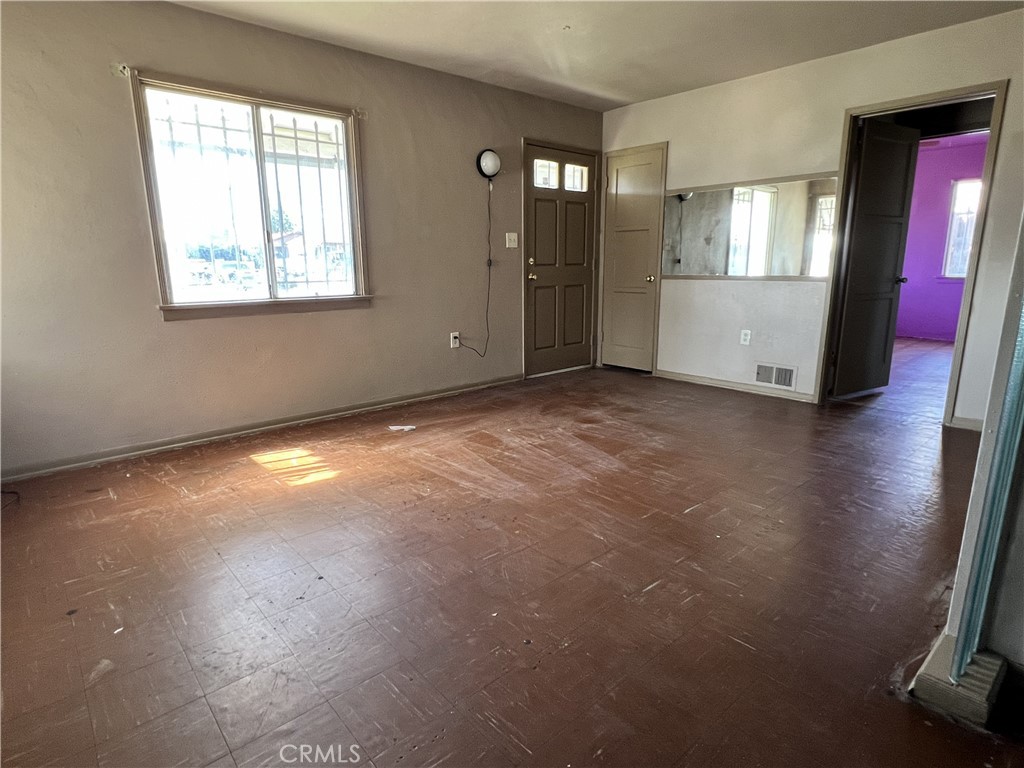 9467 Palm Lane Fontana, CA 92335 - Photo 6 of 13 an empty room with stairs and wooden floor
